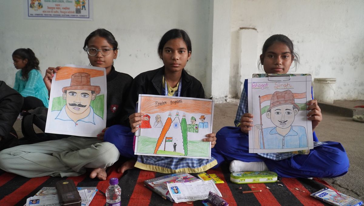 Students showing their drawings of Indian freedom fighters
