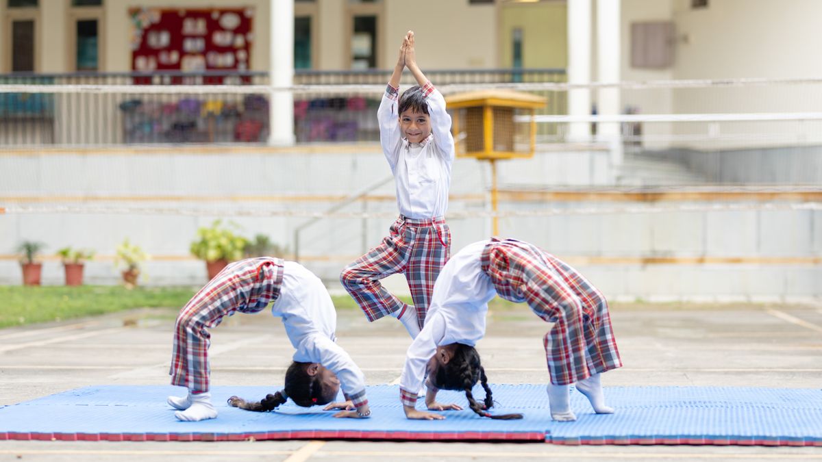 Students performing yoga asanas on the school ground
